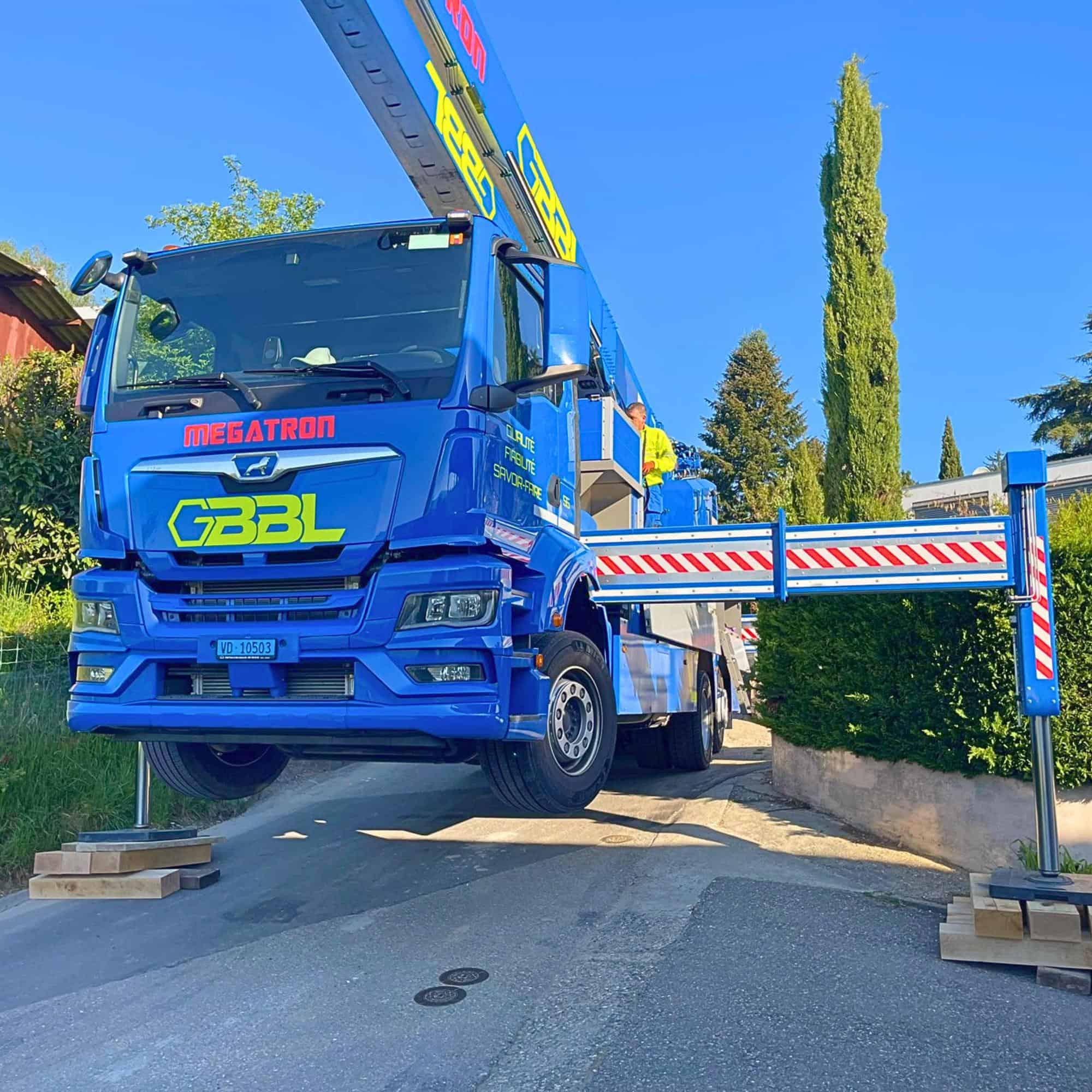 Camion de levage bleu avec plateforme élévatrice en action.