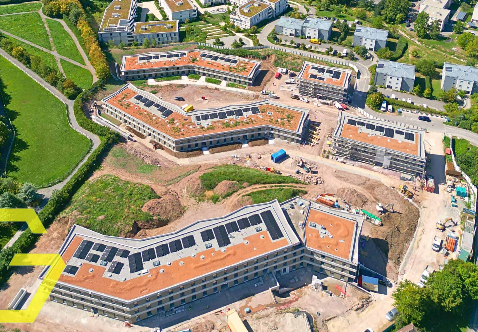 Construction de bâtiments modernes à Jongny avec panneaux solaires sur le toit.