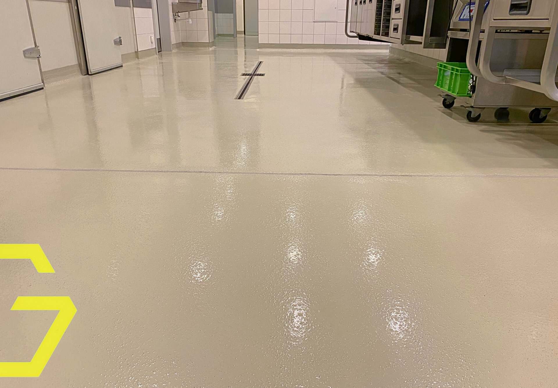 Sol en résine époxy brillant dans un environnement industriel ou hospitalier.
