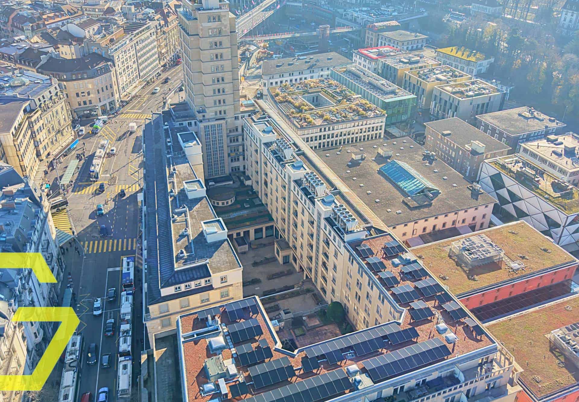 Vue aérienne du centre-ville de Lausanne avec bâtiments modernes et rues animées.