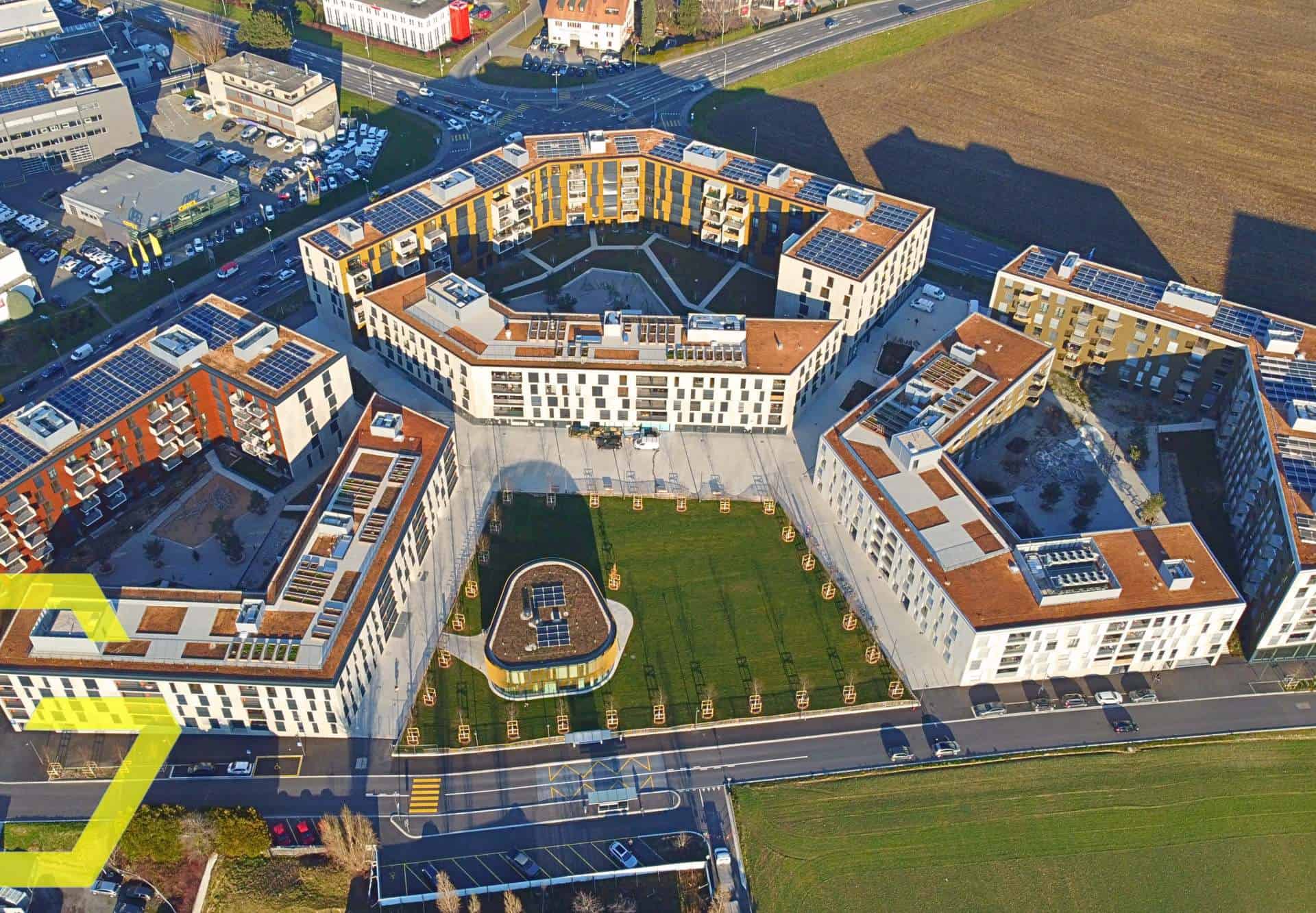 Vue aérienne d'un complexe résidentiel moderne à Crissier avec cour intérieure.