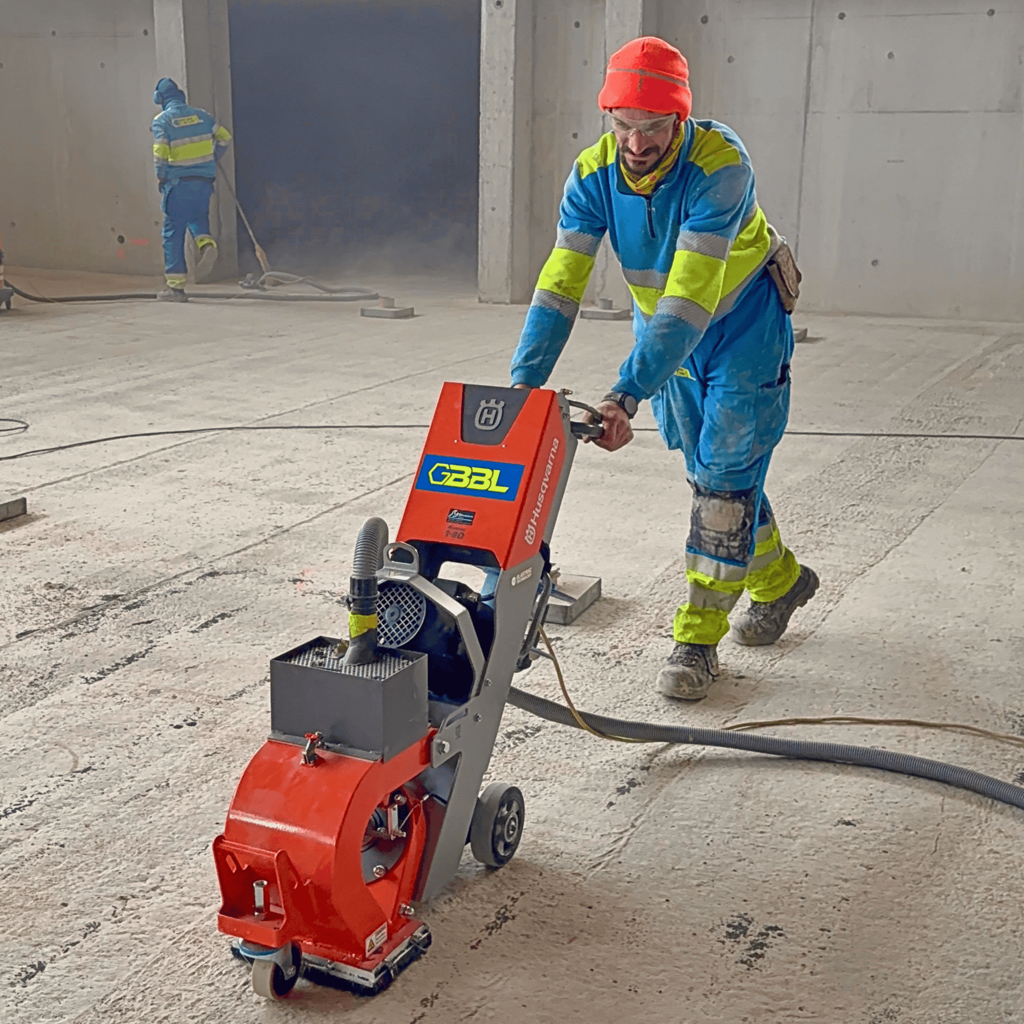 Travailleur utilisant un équipement de construction dans un bâtiment en construction.