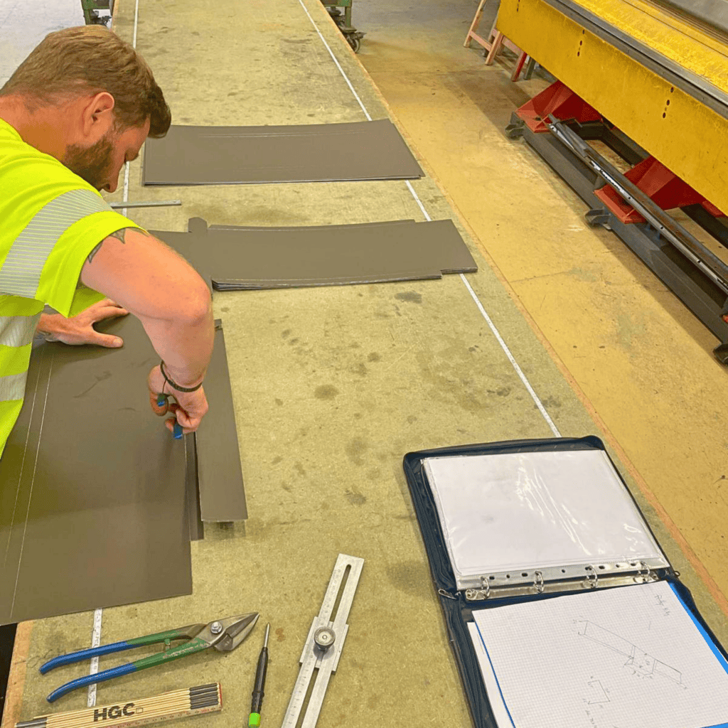 Technicien en train de préparer des panneaux en atelier industriel pour BBL SA.