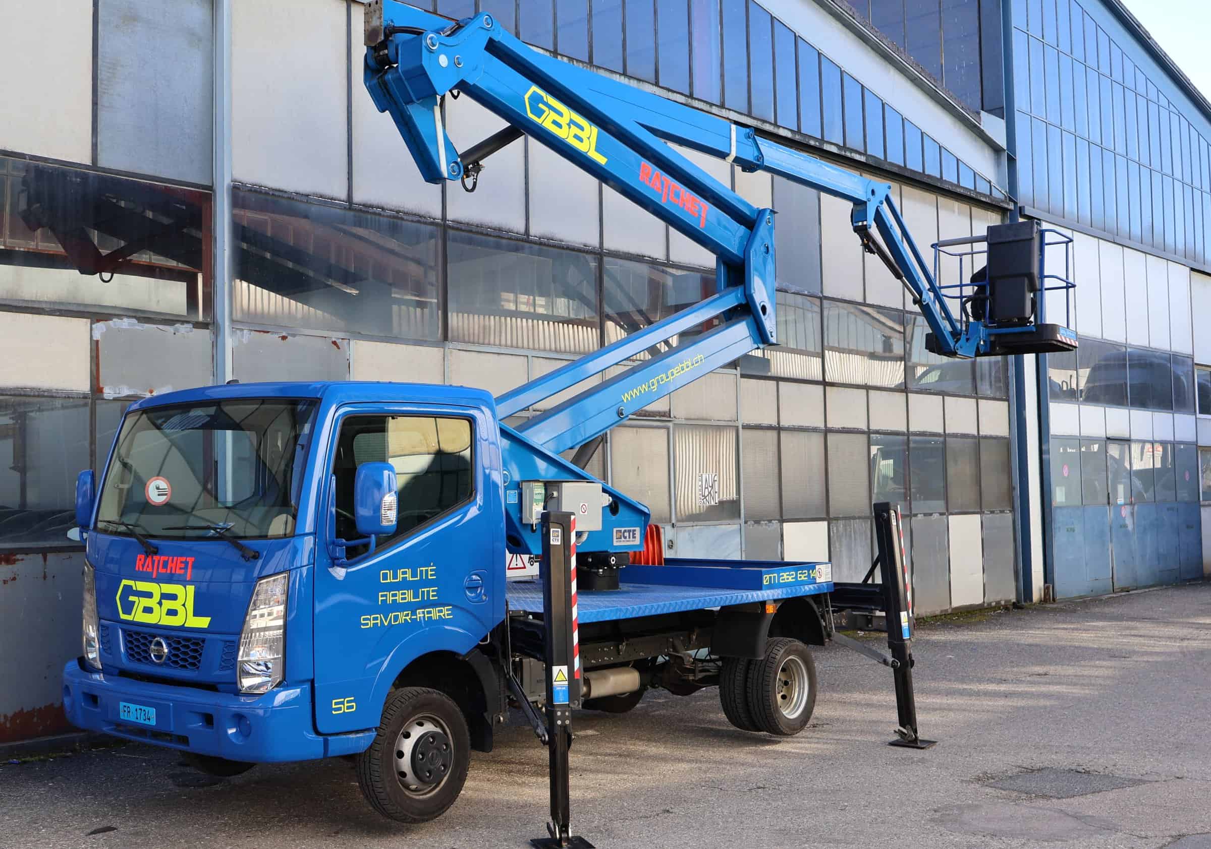 Camion avec nacelle élévatrice pour levage et transport de charges lourdes.